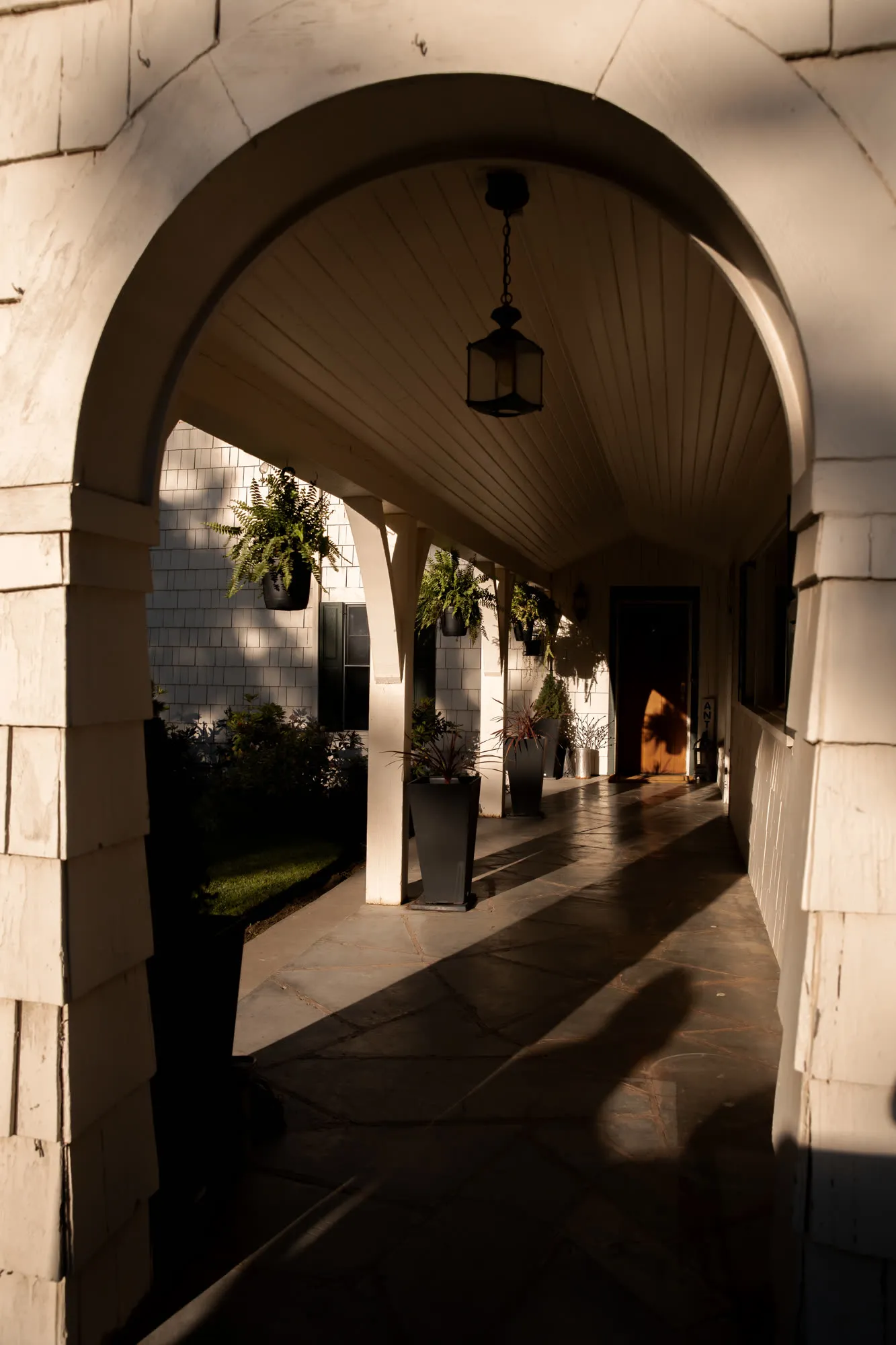 Covered breezeway with a hanging lantern and flagstone floor