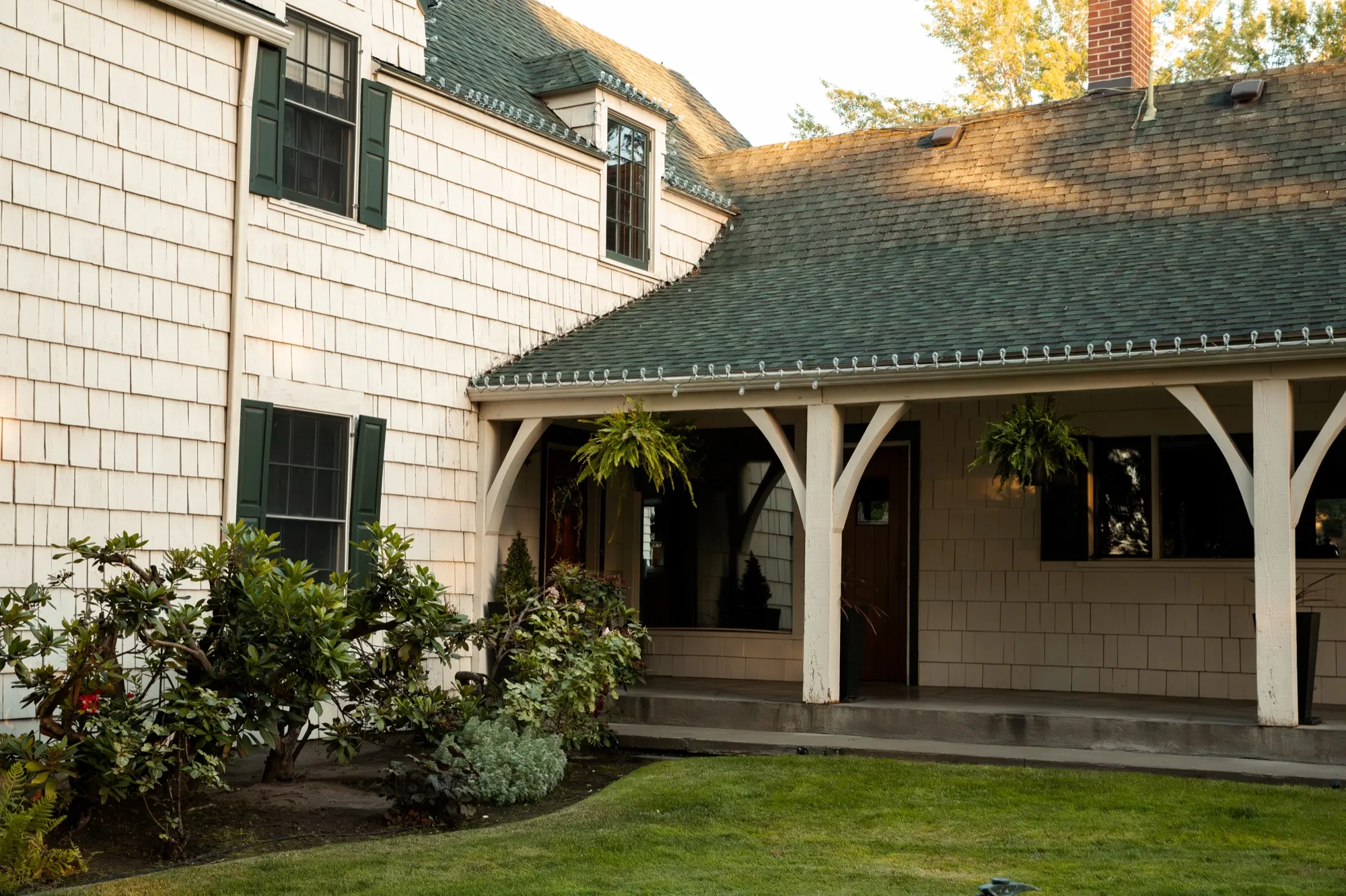 Shingle walls, green shutters, and the covered porch